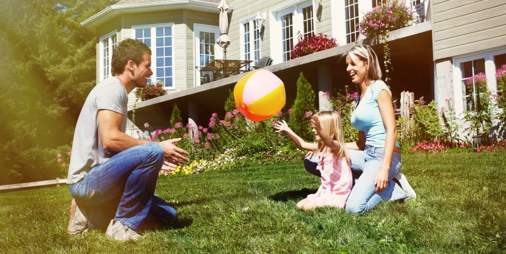 happy young family playing in their front yard