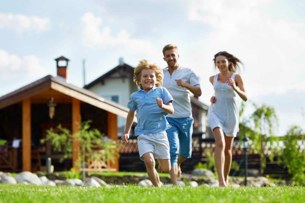 happy family running in their front lawn