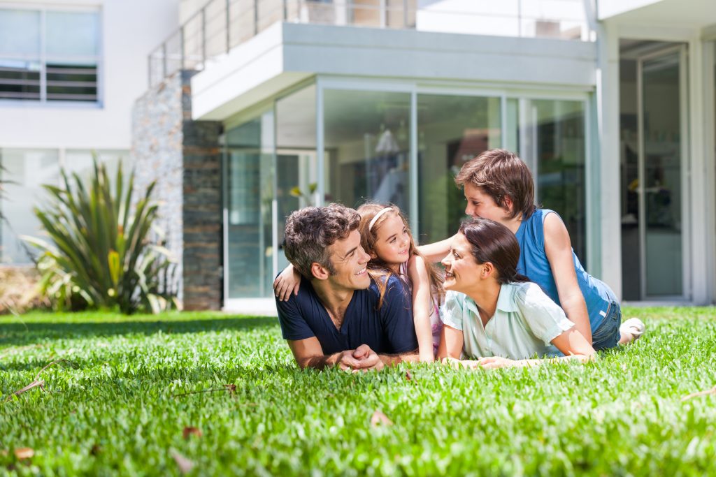 family lying on grass in their front yard