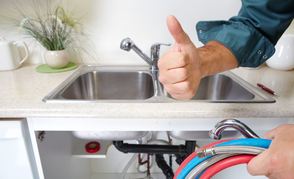 a plumber giving a thumbs up after a plumbing job